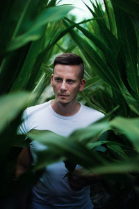 Young man surrounded by plants