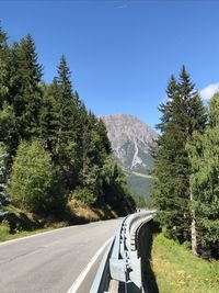 Road amidst trees against sky