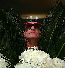 Portrait of man wearing sunglasses at red flower