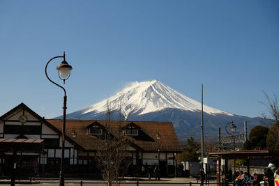 Houses against snowcapped mountains against clear sky