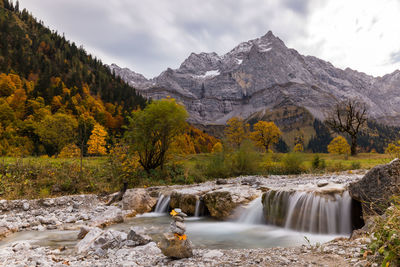 Scenic view of waterfall against mountains