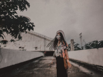 Woman standing by plants against sky