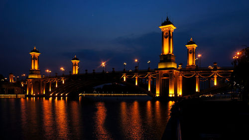 Illuminated bridge over river at night