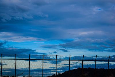 Fence against blue sky during sunset