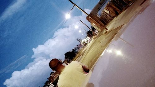 Low angle view of person against cloudy sky