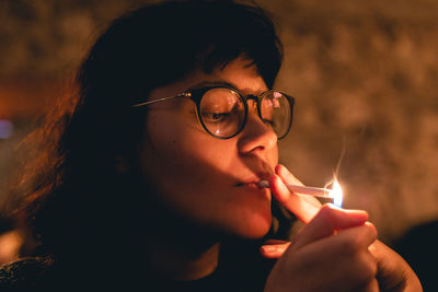 Close-up portrait of young woman holding eyeglasses