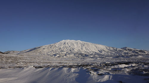 Scenic view of snowcapped mountains against clear blue sky