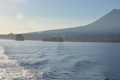 Scenic view of sea and mountains against clear sky