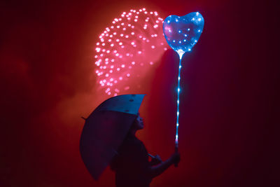 Low angle view of man holding balloons