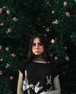 Portrait of beautiful woman standing against plants