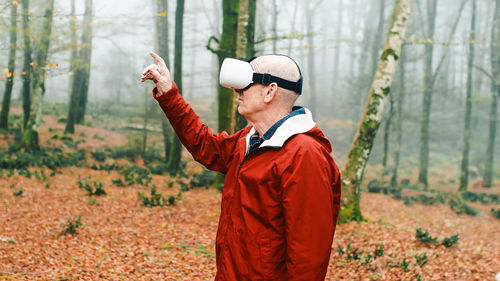 Elderly man is experienced the virtual reality in the nature into the forest