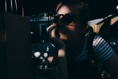 Close-up of woman with hand on chin sitting in cafe