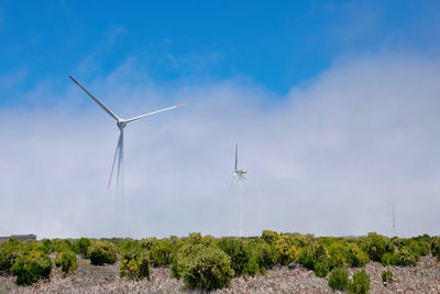 Windmill on field against sky