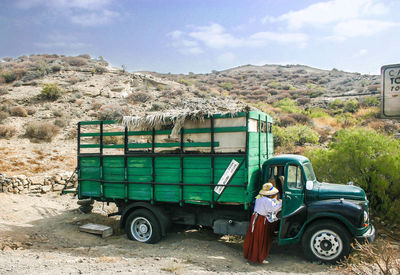 Rear view of woman standing by truck