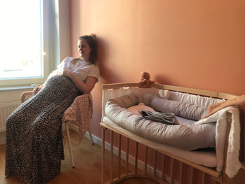 Woman sitting on bed at home