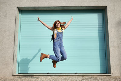 Portrait of young woman jumping