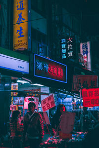 People in illuminated city at night