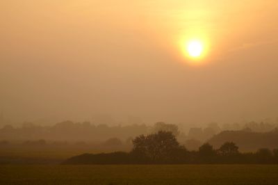 Scenic view of field against sky during sunset