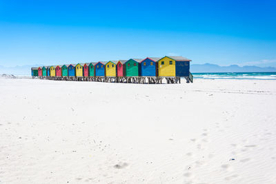 Multi colored umbrellas on beach against clear blue sky