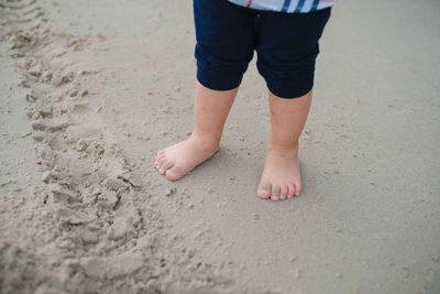 Low section of child standing on beach