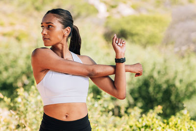 Side view of young woman exercising in park