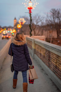 Rear view of woman with umbrella walking in winter