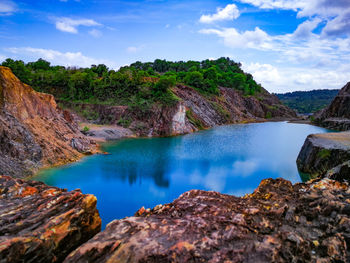Scenic view of lake and rocks against sky