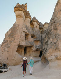 Rear view of man standing on rock formations