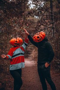 Full length of boy standing by tree during autumn