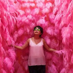 Full length portrait of woman standing on pink petals