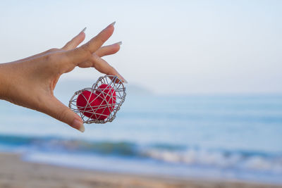 Midsection of person holding umbrella on beach