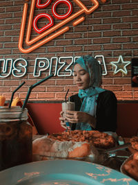 Full length of a woman with drink in restaurant