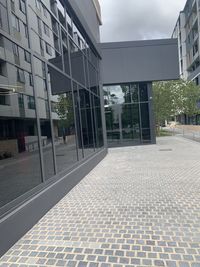 Footpath by swimming pool against buildings in city