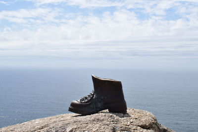 Close-up of rock in sea against sky