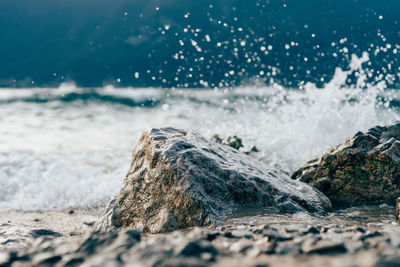 Water surface view of wave splashing on rocks in sea