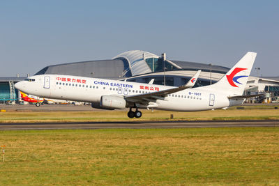 Airplane on airport runway against sky