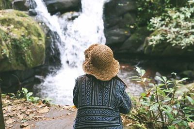 Rear view of woman against waterfall