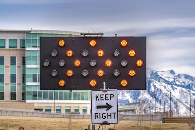 Close-up of information sign against sky during winter