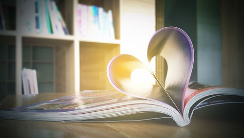Heart shape forming on book over table