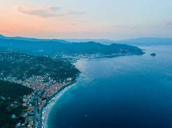 Aerial view of city by sea against sky