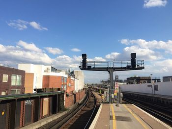 Railroad tracks against cloudy sky