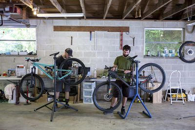 Mechanics repairing mountain bikes in bicycle shop