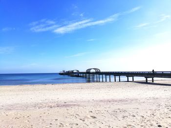 Pier on beach against sky