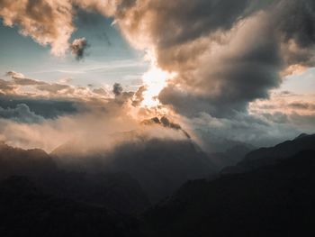 Low angle view of silhouette mountains against dramatic sky