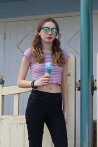 Portrait of young woman in sunglasses holding ice cream