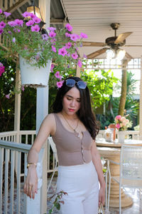 Beautiful woman standing against pink flowers