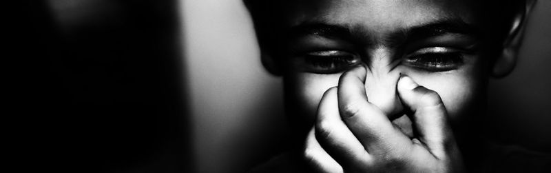 Panoramic view of boy pressing nose