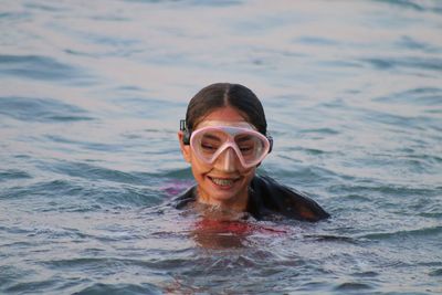 Portrait of a smiling young woman swimming in pool