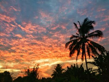 Low angle view of silhouette palm trees against romantic sky