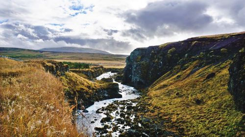 Scenic view of waterfall against sky